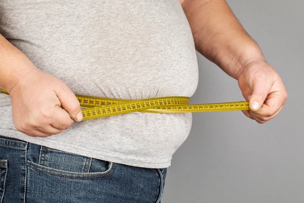 A,Man,Measures,His,Fat,Belly,With,A,Measuring,Tape.
