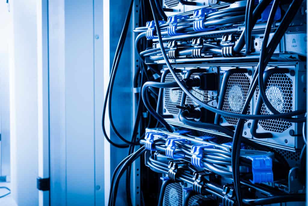Uma fileira de racks com equipamentos de fornecimento de energia (UPS) dentro de uma sala de servidores.