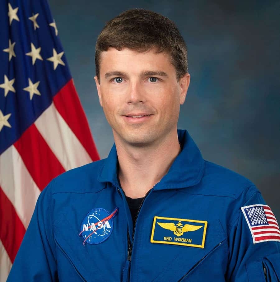 astronauta Reid Wiseman em frente à bandeira dos EUA