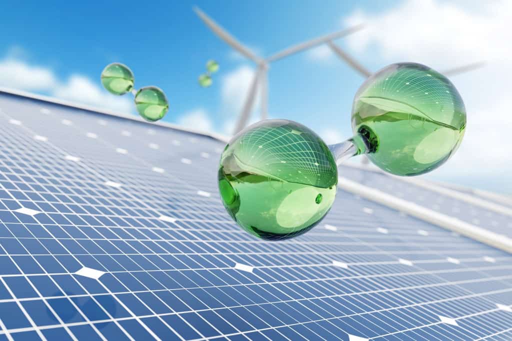 Representação de moléculas de hidrogênio sobre painel solar com turbina eólica ao fundo