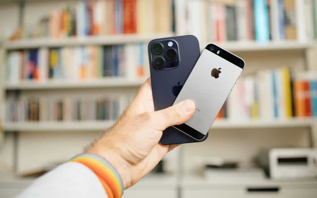 mão masculina segurando dois iphones