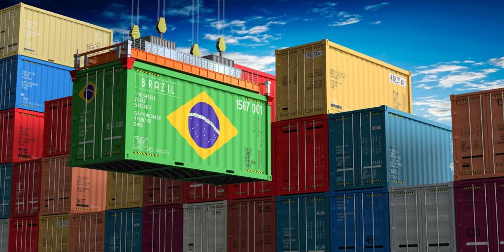 Container com bandeira do Brasil em terminal de cargas cercado por contêineres