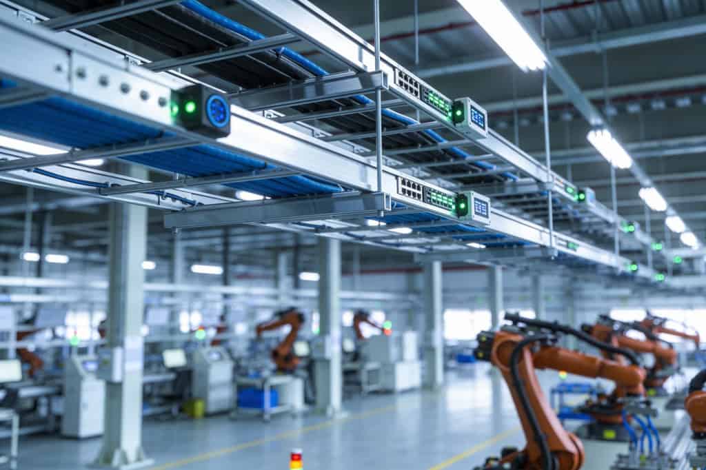 Linha de produção automatizada com braços robóticos em ambiente industrial