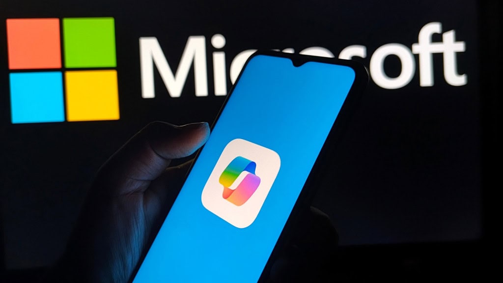 Ao fundo, logo da Microsoft; à frente, logo do Copilot em um smartphone