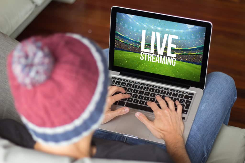 Pessoa utiliza um notebook para assistir a uma transmissão esportiva ao vivo pela internet