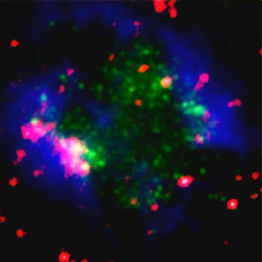 Uma imagem da galáxia Sextans A onde Vermelho indica a emissão infravermelha de poeira, azul a emissão de gás hidrogênio atômico e verde a emissão ultravioleta distante criada por estrelas recém-formadas