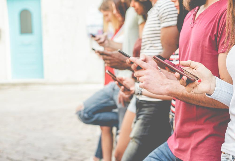 Grupo de pessoas usando o celular; telefonia móvel.