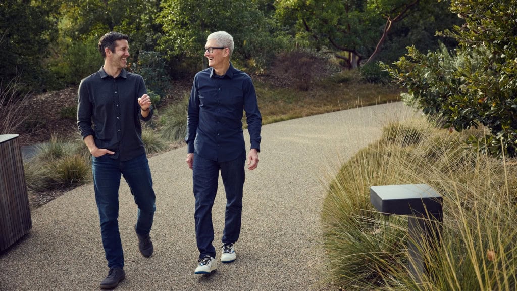 John Ternus e Tim Cook rindo enquanto caminham na Apple